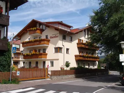 a large white building with balconies on a street at Appartement Gandler in Valdaora