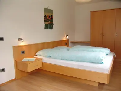 a bedroom with a large bed with a wooden headboard at Appartement Gandler in Valdaora