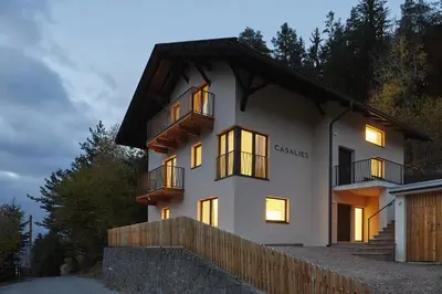 a white house with windows and a fence at Casa Lies - Apartments in Nova Ponente