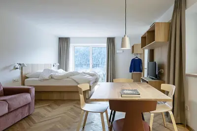 a small room with a bed and a table and a couch at Casa Lies - Apartments in Nova Ponente