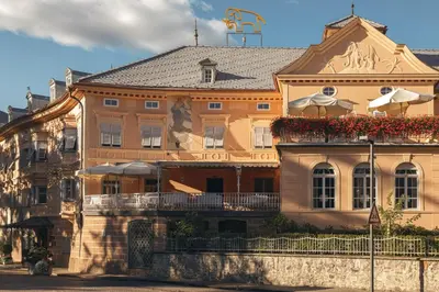 a large orange building with a balcony in front of it at Hotel Elephant in Bressanone