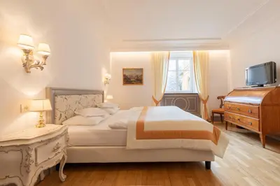 a bedroom with a bed and a dresser and a television at Hotel Elephant in Bressanone