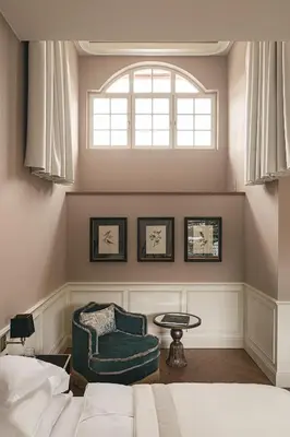 a bedroom with a bed and a chair and a window at Hotel Elephant in Bressanone