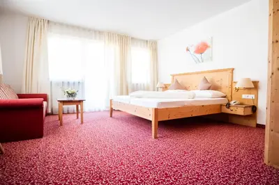 a bedroom with a bed and a red carpet at Wohlfühlhotel Mei Auszeit in Plaus