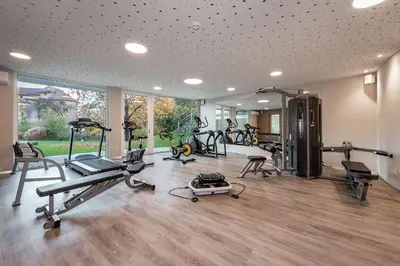 a gym with several treadmills and exercise bikes at Baumgartner's Blumenhotel in Schenna