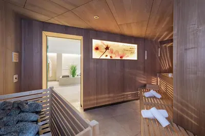 a room with two benches and a picture on the wall at Baumgartner's Blumenhotel in Schenna