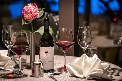 a bottle of wine sitting on a table with wine glasses at Baumgartner's Blumenhotel in Schenna