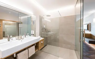 a bathroom with a sink and a shower at Baumgartner's Blumenhotel in Schenna