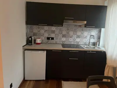 a small kitchen with black cabinets and a sink at LaCasadiGuendy in Bolzano