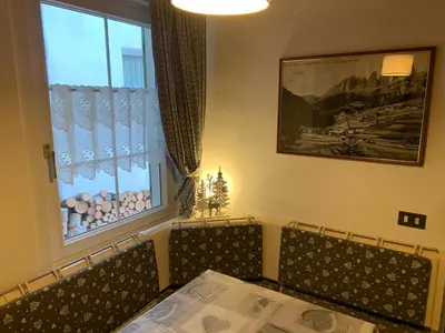 a dining room with a table and chairs and a window at Cèsa Viosadea in Campitello di Fassa