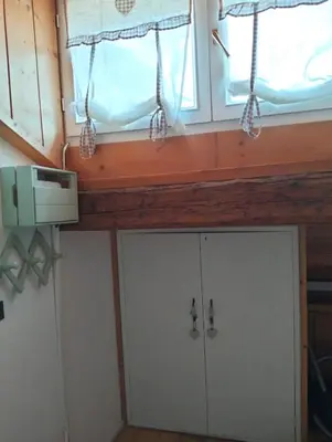 a room with two white cabinets and a window at Cèsa Viosadea in Campitello di Fassa