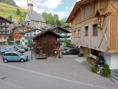 a small town with cars parked in a parking lot at Cèsa Viosadea in Campitello di Fassa
