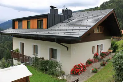 a house with a roof with flowers in the yard at Haus Tasser in San Lorenzo di Sebato