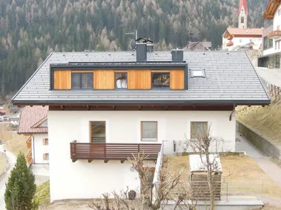 a white house with a black roof at Haus Tasser in San Lorenzo di Sebato