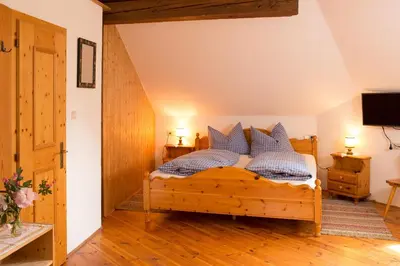 a bedroom with a wooden bed with blue and white pillows at Krüglwirt in San Lorenzo di Sebato