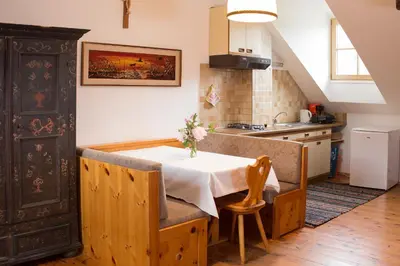 a kitchen with a table with a vase of flowers on it at Krüglwirt in San Lorenzo di Sebato