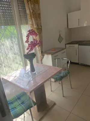 a kitchen with a table and a vase with flowers on it at Obsthof Klotz in Frangarto