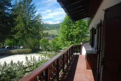 a balcony with a view of a river and mountains at Luxury Panoramic 3BR Apt 2min to Centre 5min to Lifts in Cortina dʼAmpezzo