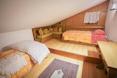 a attic bedroom with two beds and a couch at Luxury Panoramic 3BR Apt 2min to Centre 5min to Lifts in Cortina dʼAmpezzo
