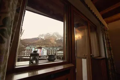 a window in a room with a view of a mountain at Luxury Panoramic 3BR Apt 2min to Centre 5min to Lifts in Cortina dʼAmpezzo