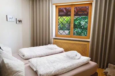 two beds in a room with a window at Apartment Cascada - Alpstay in Parcines