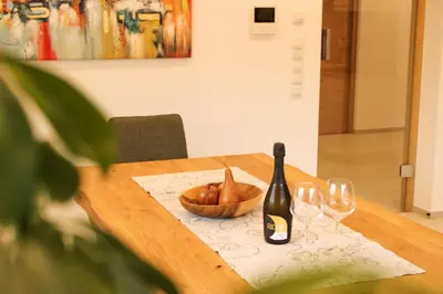 a table with a bottle of wine and two glasses at Residence Klementhof in Naz-Sciaves
