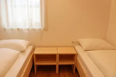 a small room with two beds and a table at Residence Klementhof in Naz-Sciaves