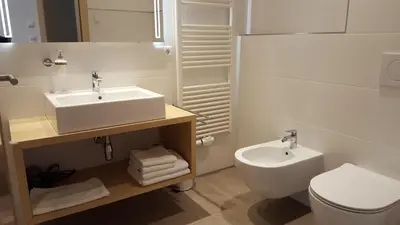 a white bathroom with a sink and a toilet at Residence Klementhof in Naz-Sciaves
