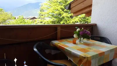 a table with a vase of flowers on a balcony at Residence Klementhof in Naz-Sciaves
