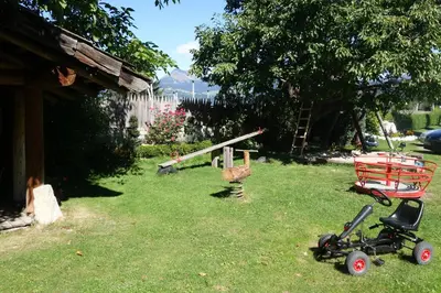 a yard with a cart and a stroller in the grass at Residence Klementhof in Naz-Sciaves