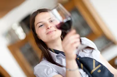 a woman holding a glass of red wine at Hotel & Appartement Valtnaungut in Cermes