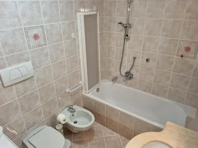 a bathroom with a tub and a toilet and a sink at Ciapià in Campitello di Fassa