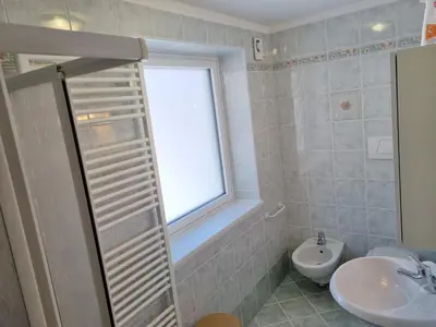 a bathroom with a window and a sink and a toilet at Ciapià in Campitello di Fassa