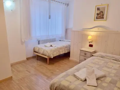 a bedroom with two beds and a window at Ciapià in Campitello di Fassa