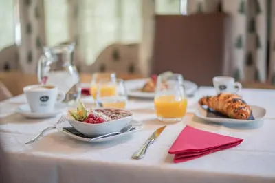a table with plates of food and glasses of orange juice at Camping Sass Dlacia in San Cassiano