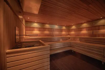 a sauna with wooden walls and a large tub at Camping Sass Dlacia in San Cassiano