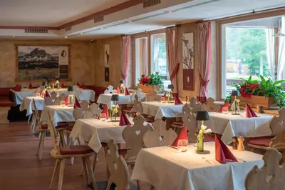 a restaurant with white tables and chairs with red napkins at Camping Sass Dlacia in San Cassiano