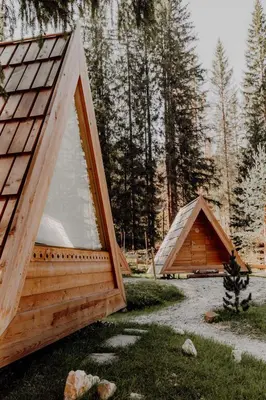 two tents in a field with trees in the background at Camping Sass Dlacia in San Cassiano