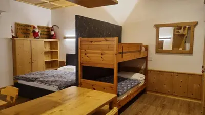 a bedroom with a bunk bed and a wooden table at Casa Cortina - presso Sussy Residence in Falcade