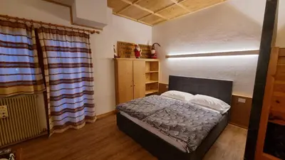 a small bedroom with a bed in a room at Casa Cortina - presso Sussy Residence in Falcade
