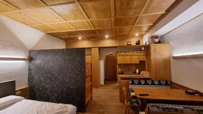 a room with a bed and a desk in a room at Casa Cortina - presso Sussy Residence in Falcade