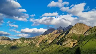 a view of a mountain range with clouds in the sky at Casa Cortina - presso Sussy Residence in Falcade