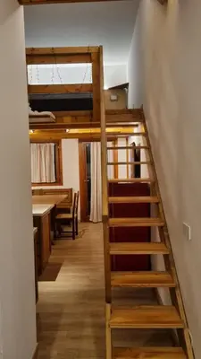 a staircase in a room with a loft bed at La Casa Degli Orsi - presso Sussy Residence in Falcade