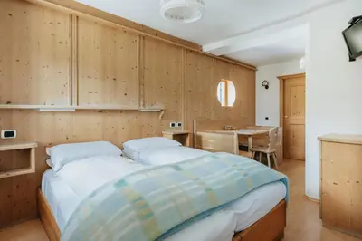 a bedroom with a bed and a table in it at Locanda Montana in San Vito di Cadore
