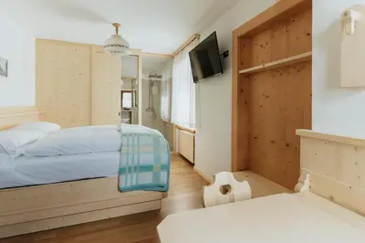 a hotel room with a bed and a tv at Locanda Montana in San Vito di Cadore