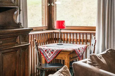 a table with a red candle on it next to a window at Chalet Scherlin in Ortisei