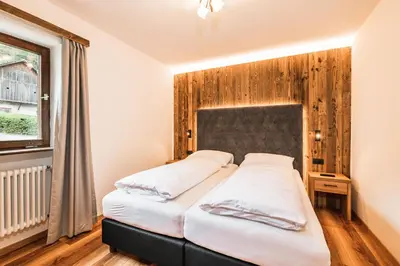 a bedroom with two beds and a window at Chalet Scherlin in Ortisei