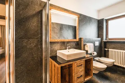 a bathroom with a sink and a toilet at Chalet Scherlin in Ortisei