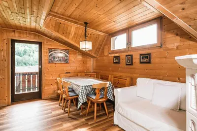 a dining room with a table and a couch at Chalet Scherlin in Ortisei