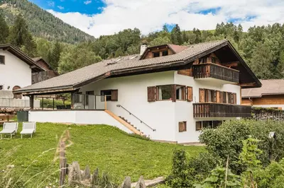a house in the mountains with a yard at Chalet Scherlin in Ortisei